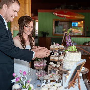 bride groom cutting wedding cake dessert table indoor