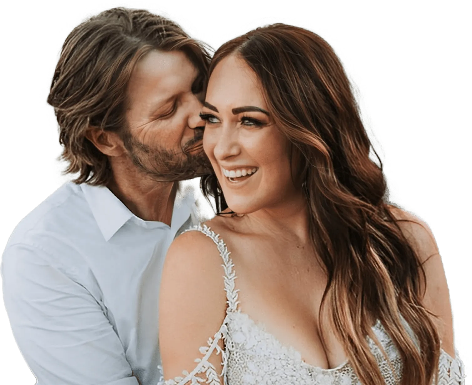 Smiling woman in white dress embraced by man in white shirt during a romantic moment