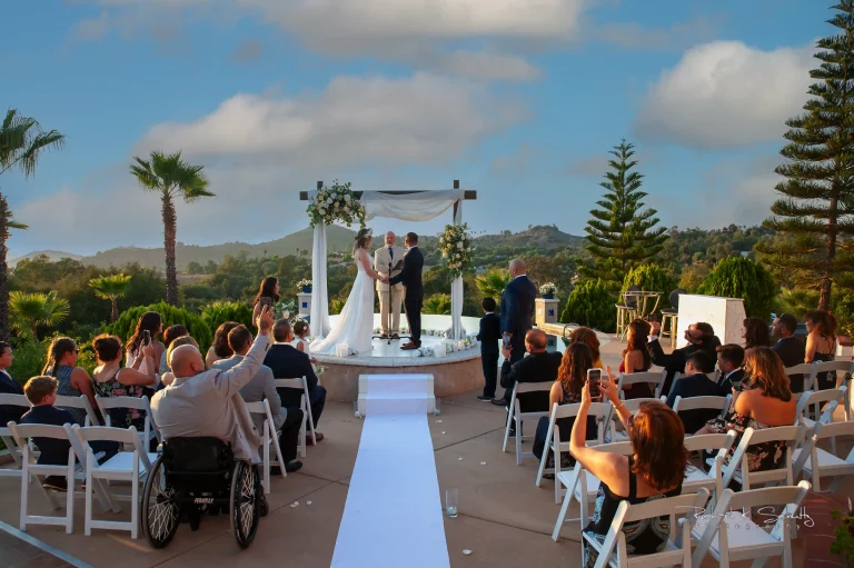 Bride and groom exchanging vows outdoors during a San Diego wedding ceremony