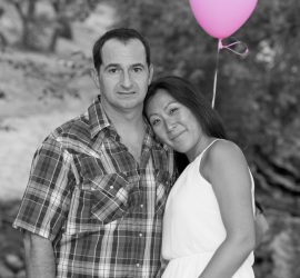 © 2019 RKS Photography | https://rksshots.com A man and woman stand together outdoors; the woman holds a pink balloon and leans her head on the man's shoulder.